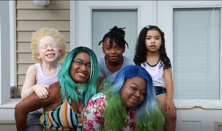 family smiling outside home