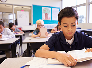 boy reading a book in school