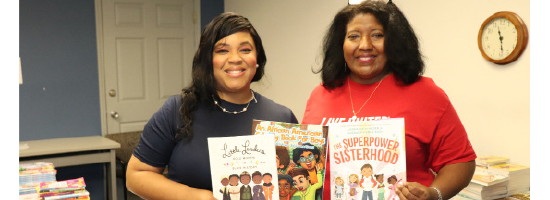 AALC members smiling holding up books