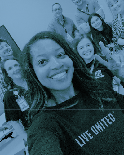Selfie of 4 ladies smiling, the one in the middle is wearing a LIVE UNITED shirt