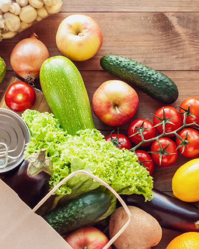 Image of fresh fruits and vegetables spilling out of a brown paper bag