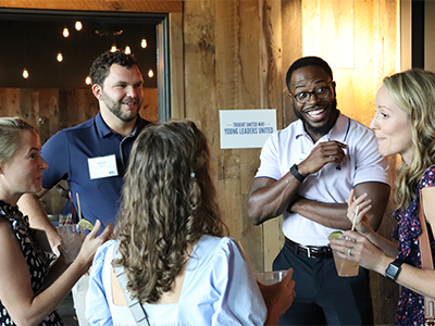 YLU group of people smiling, conversating, and networking with one another.