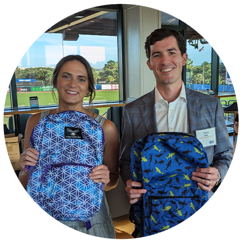 2 ylu members holding backpacks and smiling at camera