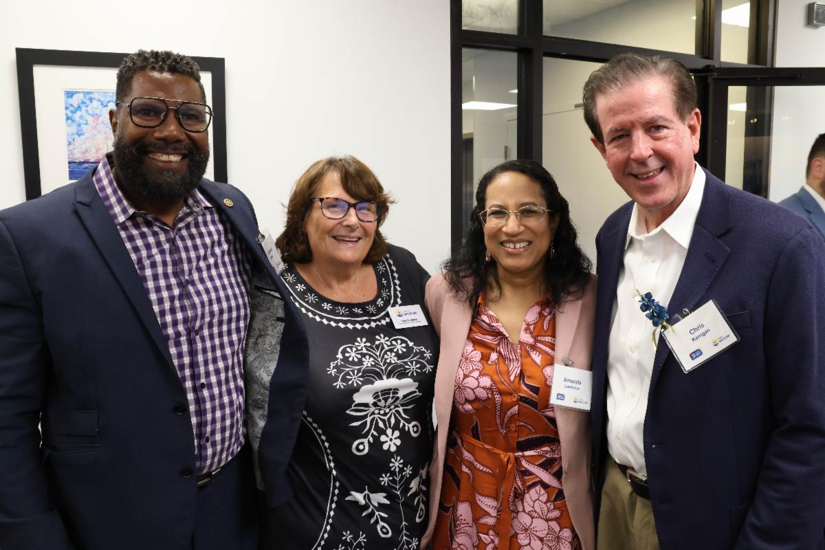A group of TUW supporters smile and pose for a photo at the 80th Anniversary Celebration.