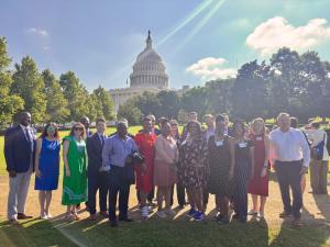 A group of individuals posing for a photo with Capitol Hill in the background