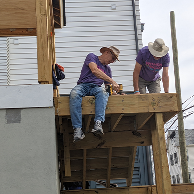 two volunteers helping to build a house for habitat for hummanity