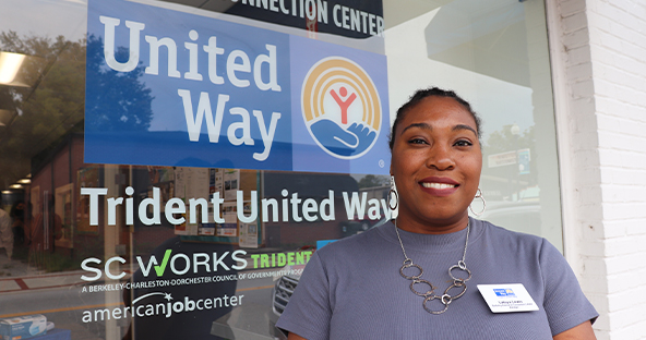 Graphic of Trident United Way staff member standing outside of the Berkeley Resource Connection Center posing in front of logo on building