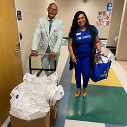 Sonia Hanson and principal with bags of donated books