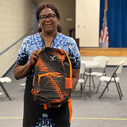 St Stephens elementary school principal holding donated backpack