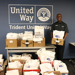 Don Smith holding bags of donated books at Trident United Way office