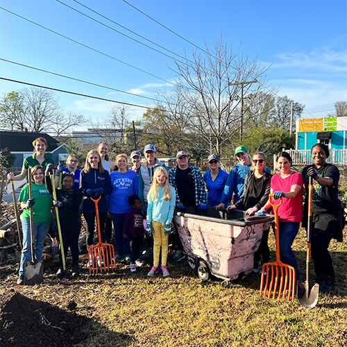 Members of Women United and children volunteering at fresh future farm