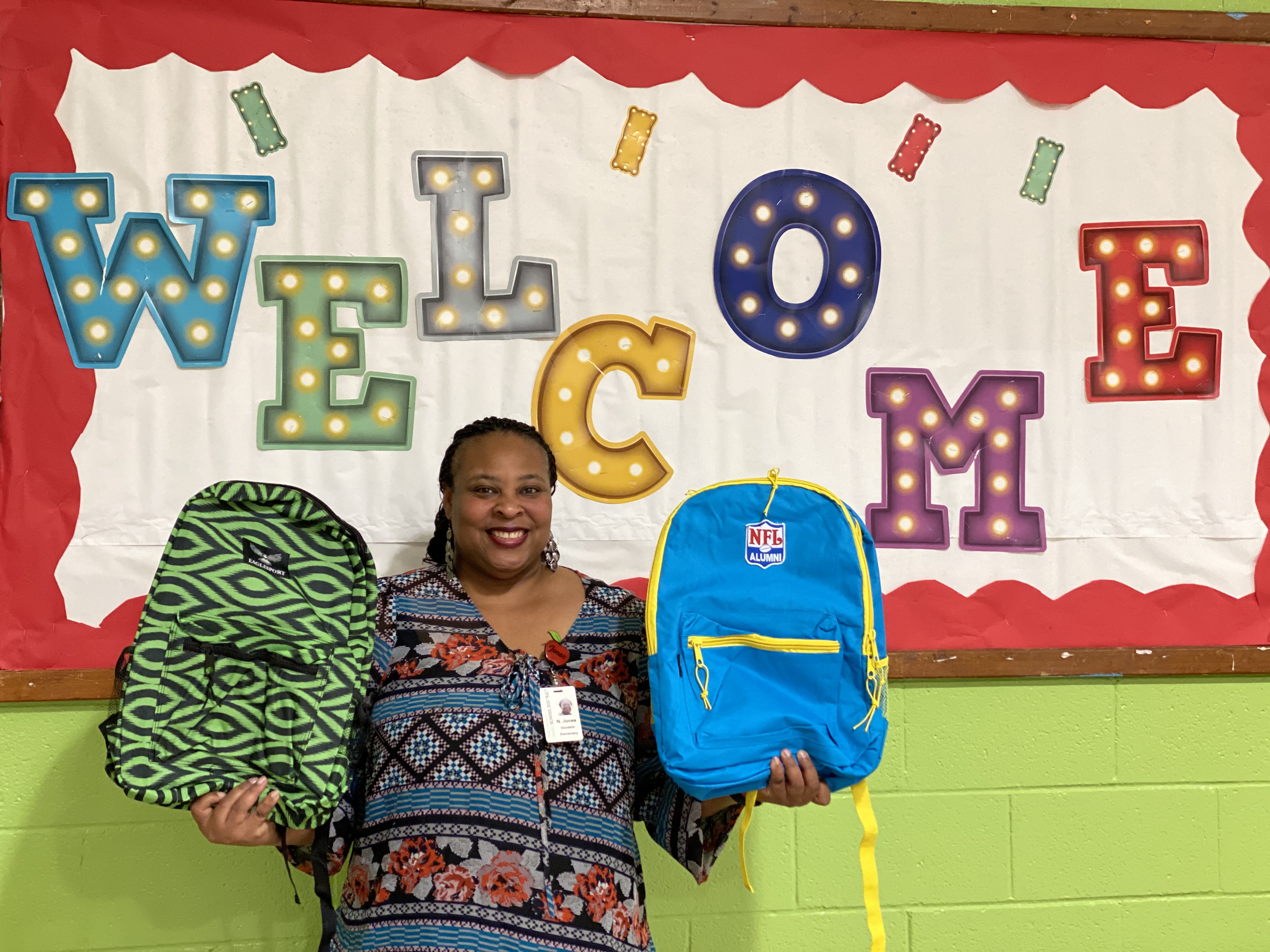 Principal Natasha Jones holding backpacks at school