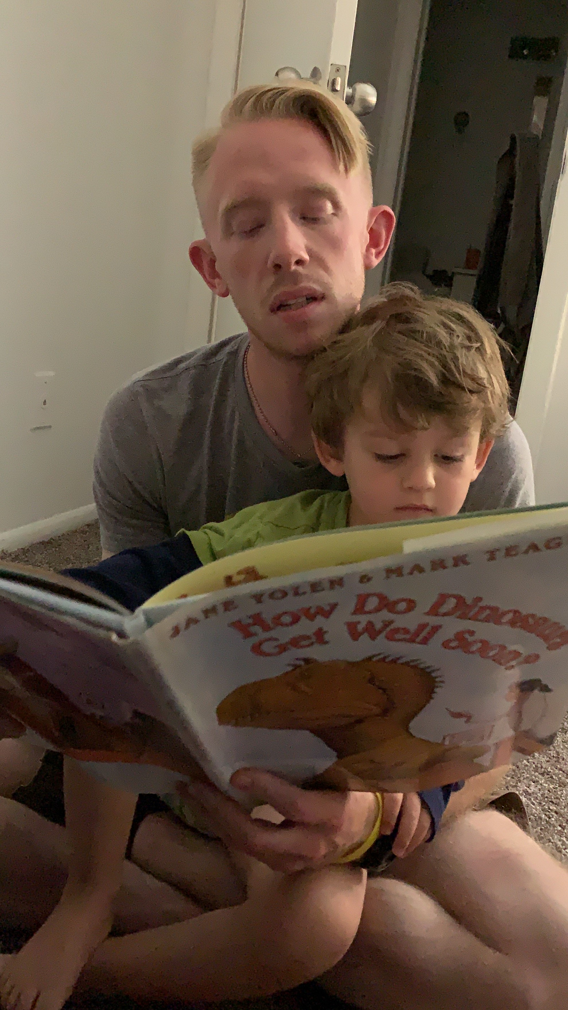 man reading book with child on lap