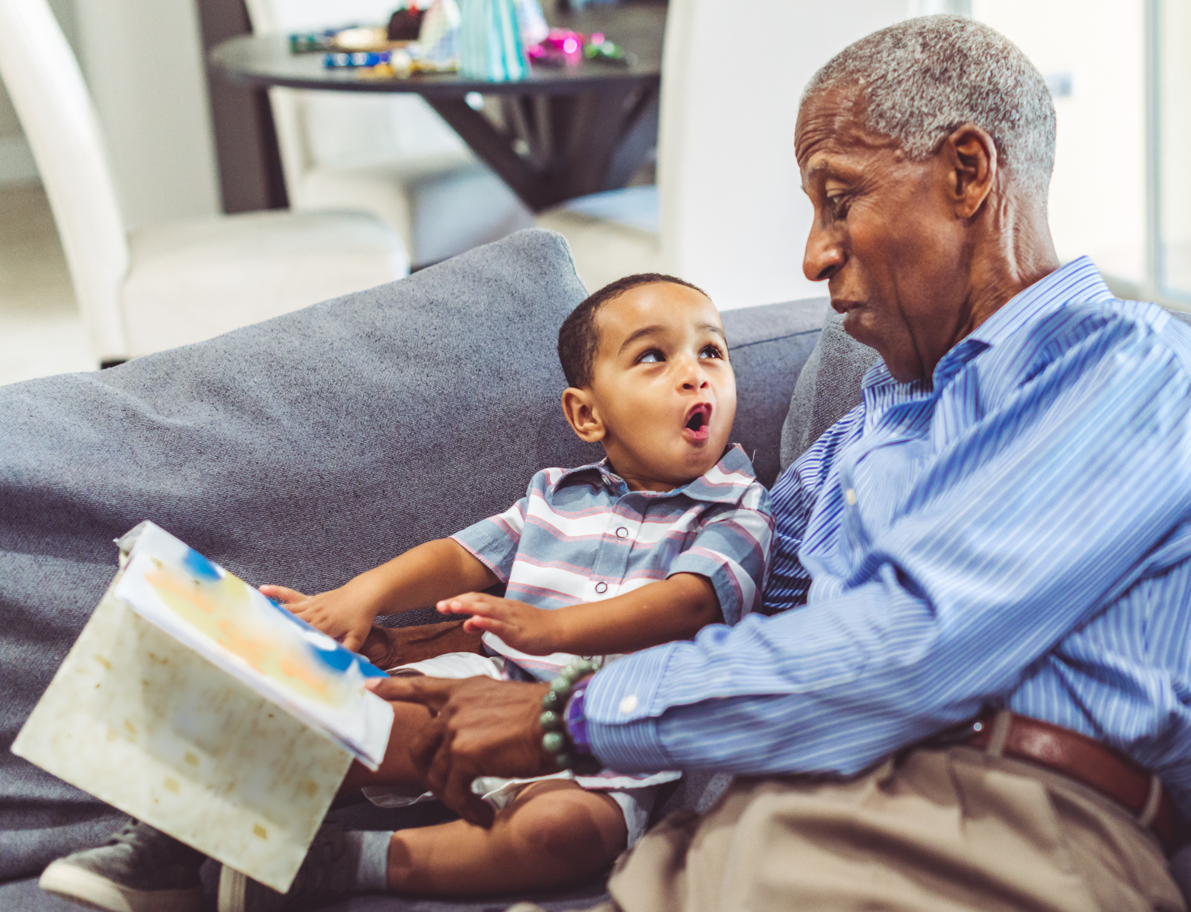 grandather reading book to baby