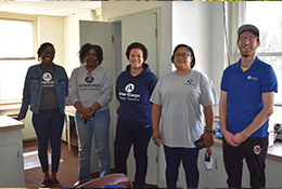 AmeriCorps members posing for photo inside a room they were helping to clean out