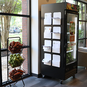 Side view of a free and fresh fridge showing several manilla folders attached to the side that contain recipe and nutrition cards