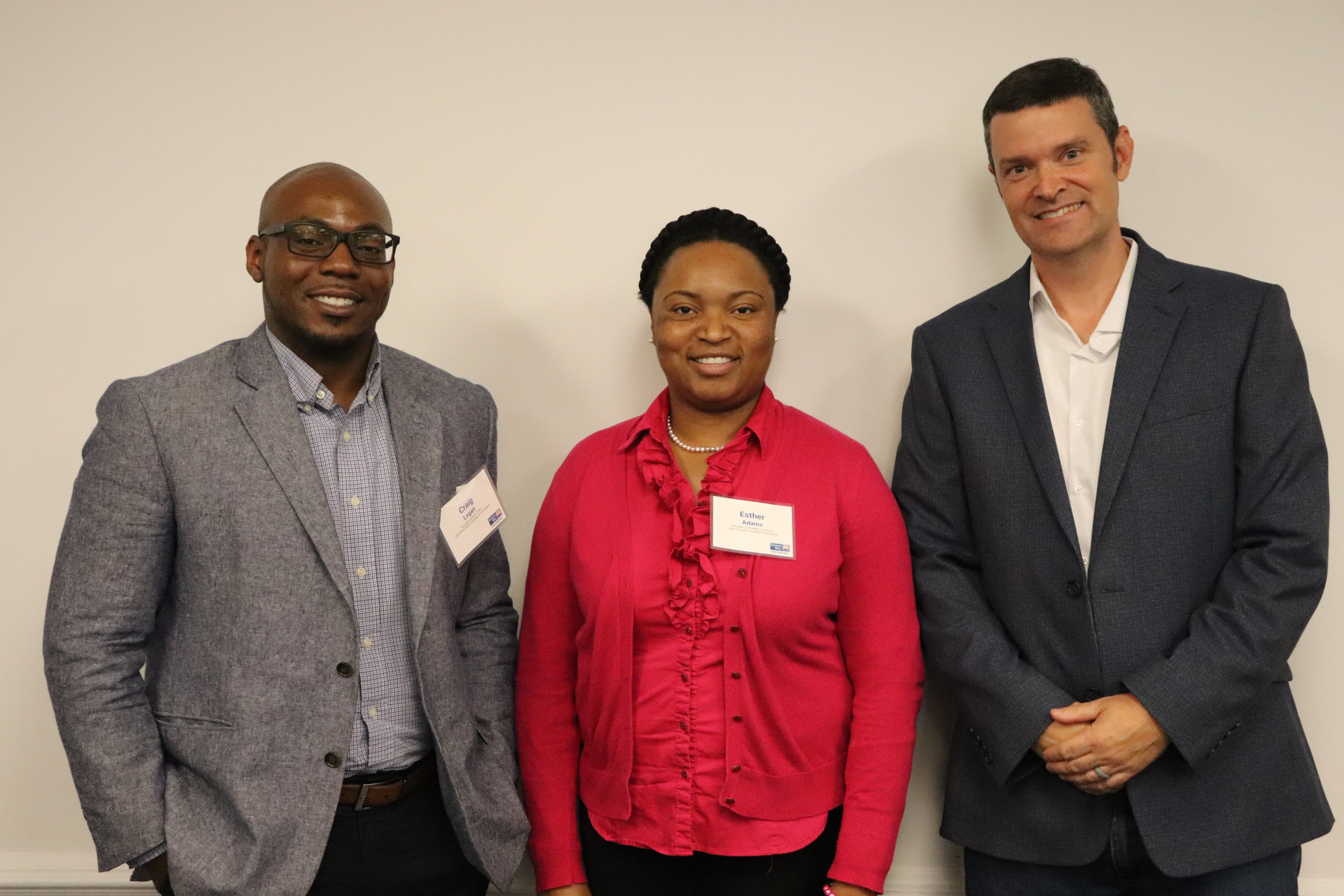 "Three speakers stand and smile. Left to right: Craig Logan, Esther Adams, Bill Standfield."