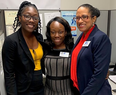 Three AmeriCorps members smiling for a picture