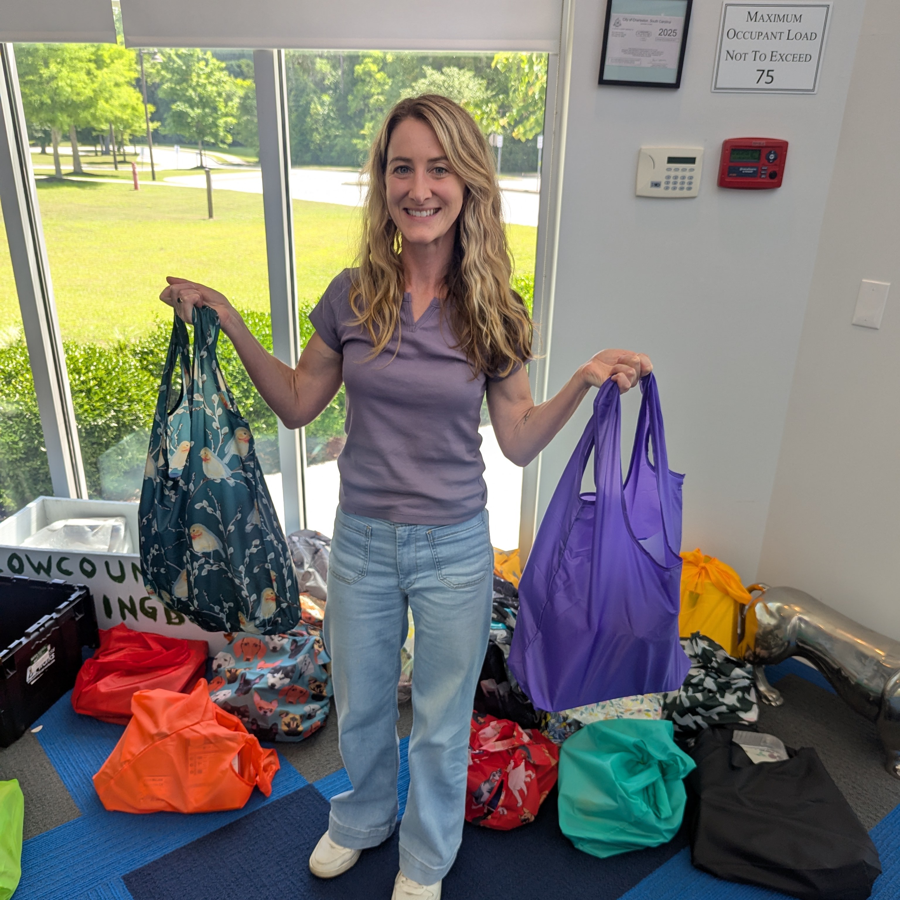 A volunteer holds 2 bags for a supply drive that she collected.