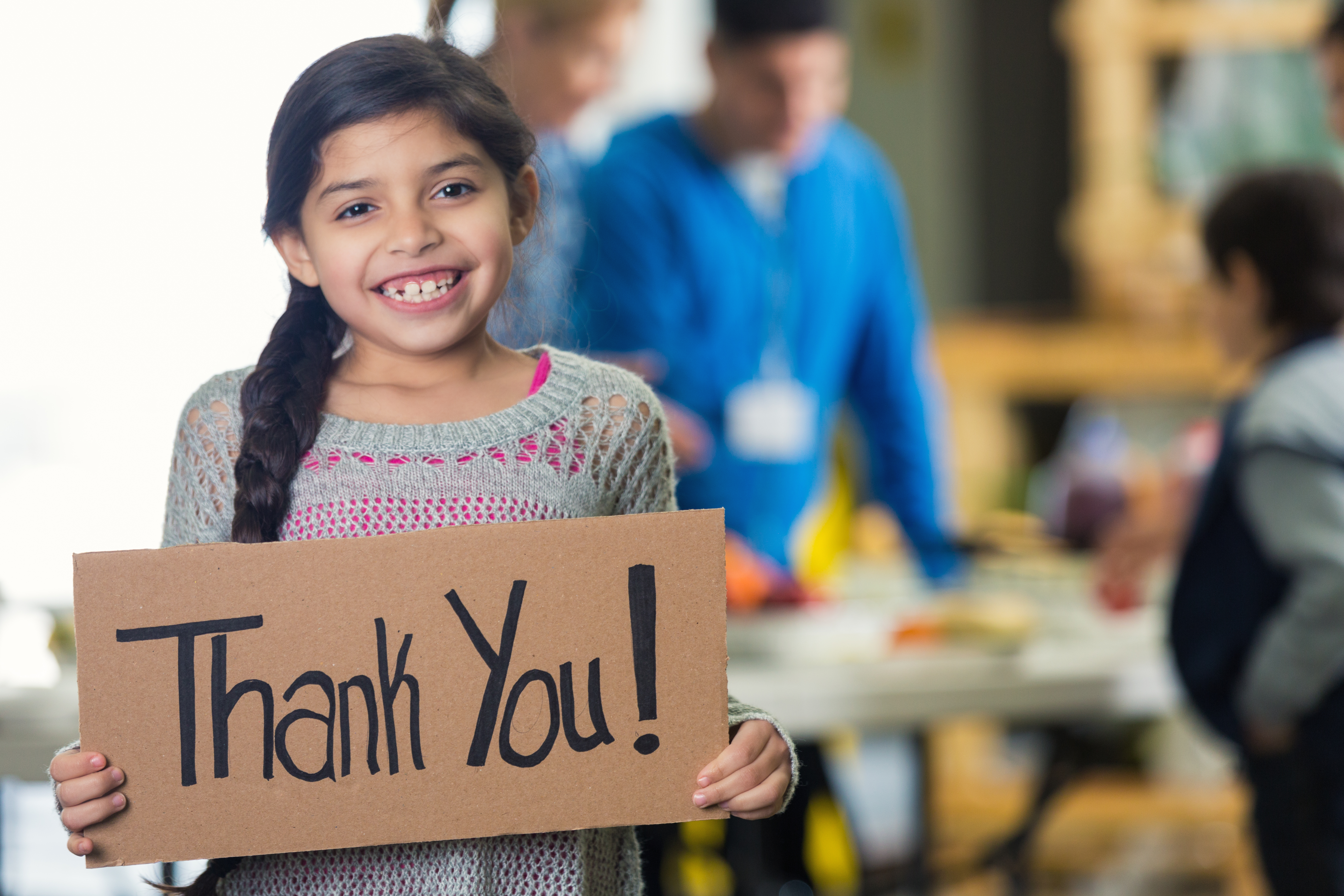 Young Girl Holding Cardboard Thank You sign