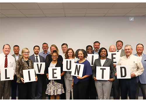Photo of 2022-23 board members, some hold letters that spell out LIVE UNITED
