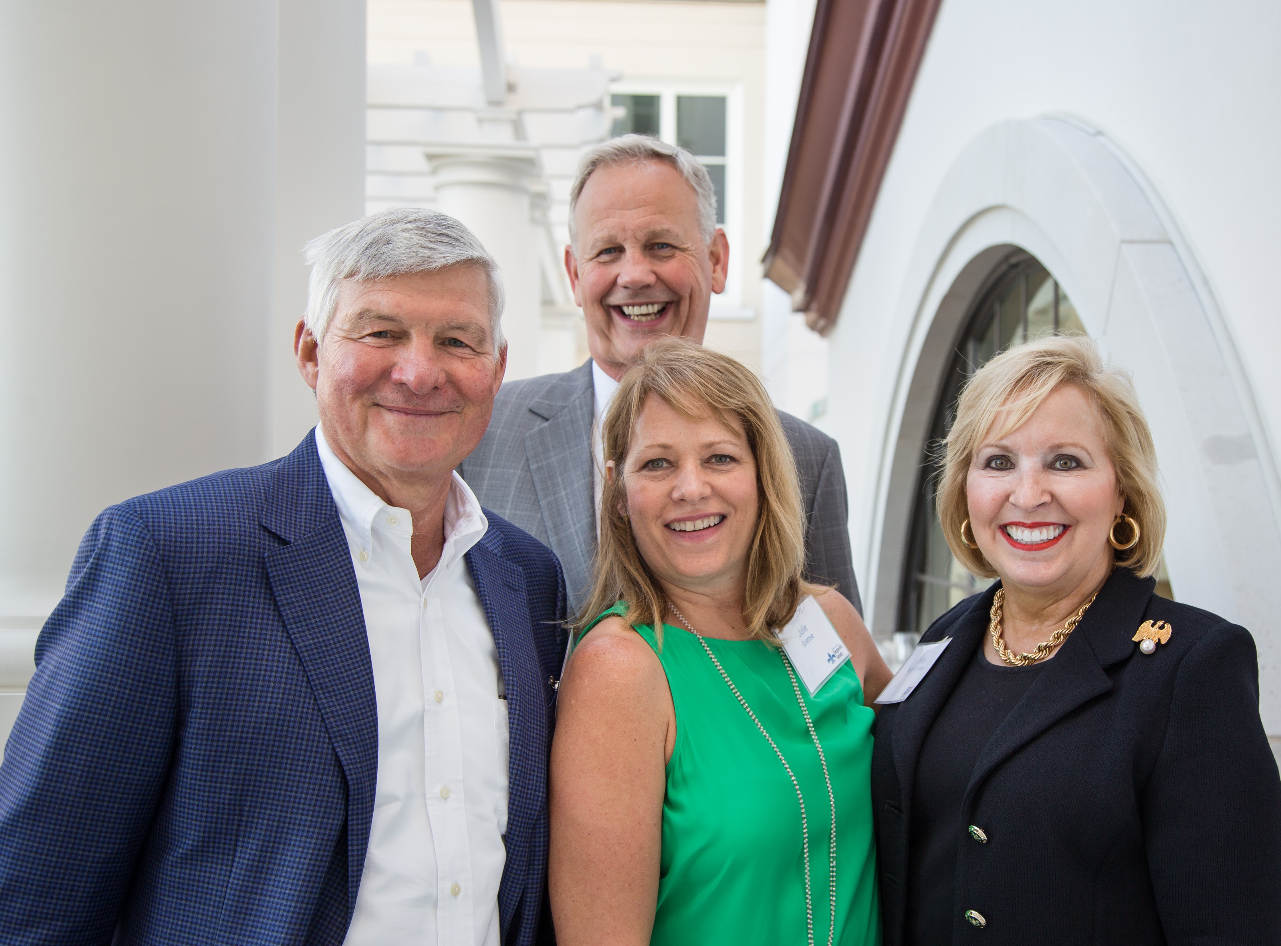 "Four people stand and smile. Furthest to the right is CEO Chloe Knight Tonney."