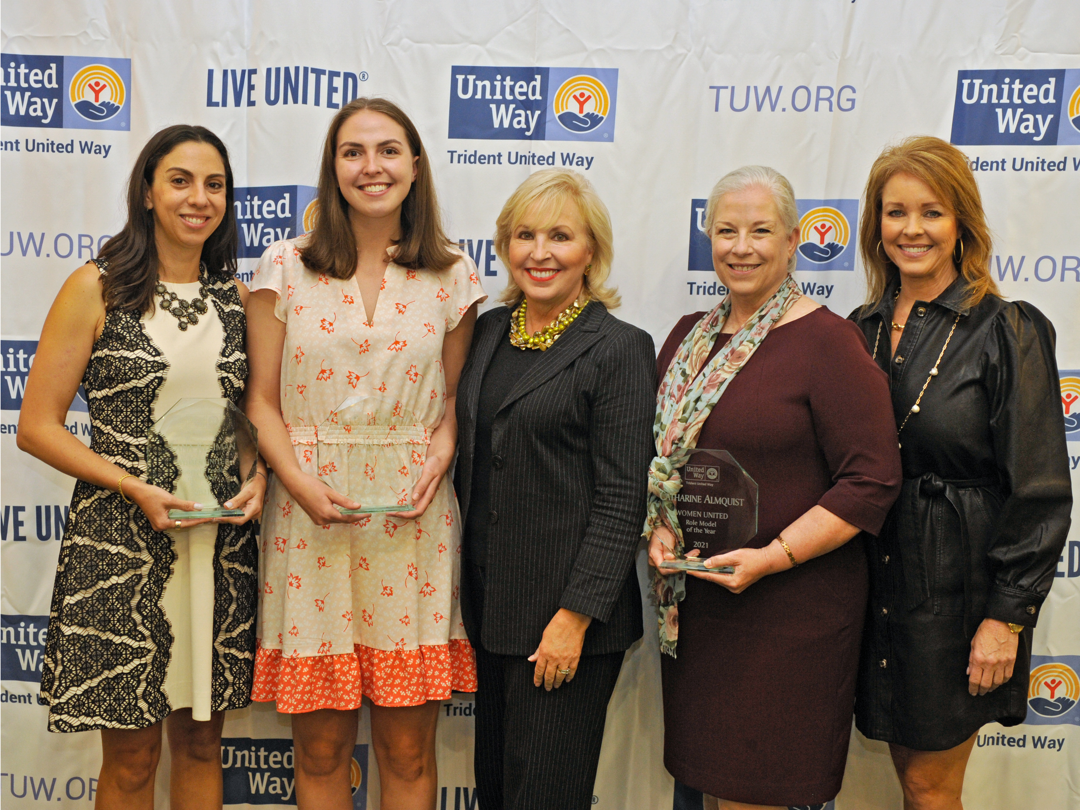 “Five women stand and smile in front of a Trident United Way background. Three are the event’s honorees holding their awards.”