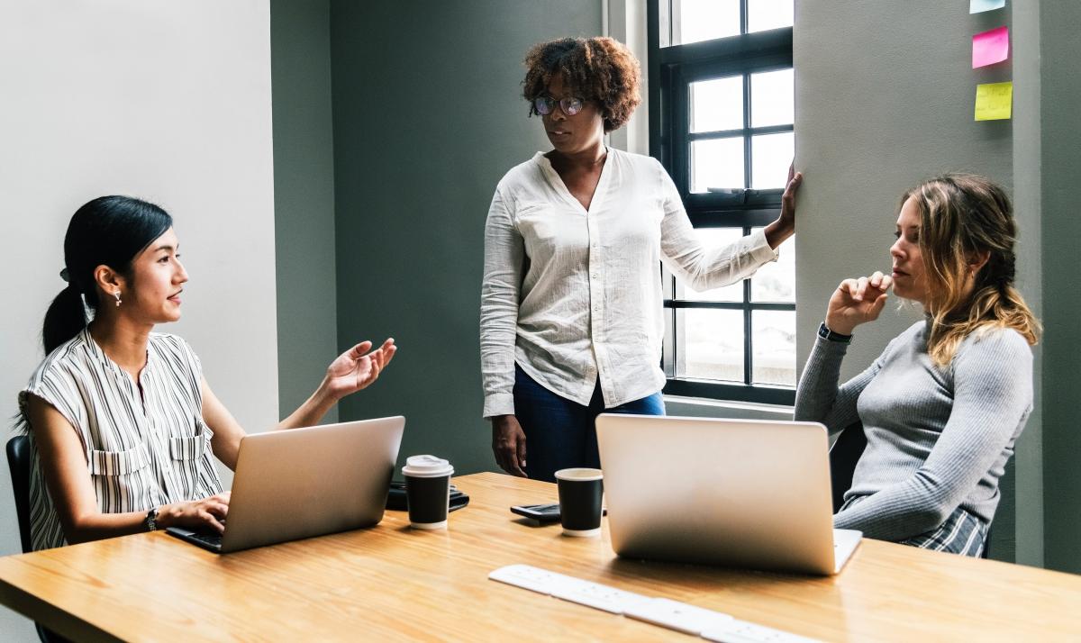 3 women sitting in a meeting discussing