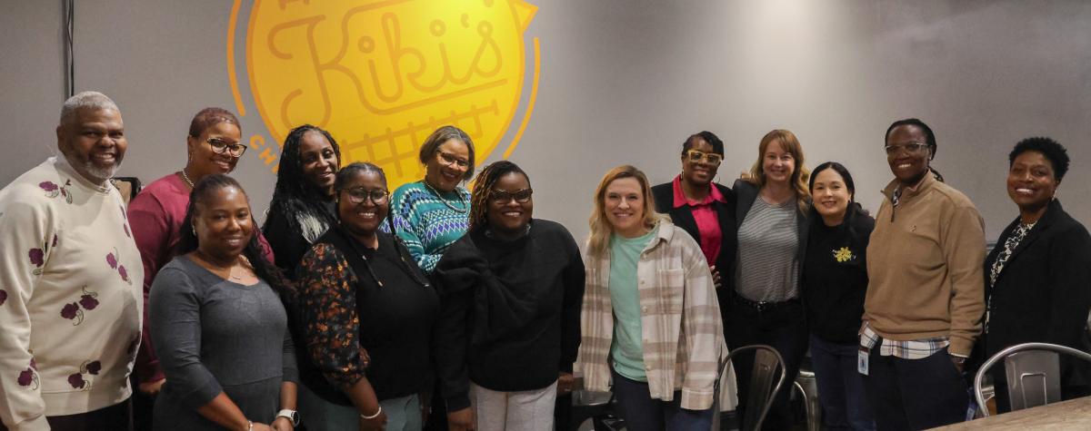Members of PULSE stand together, smiling at the camera at Kiki's Chicken & Waffles