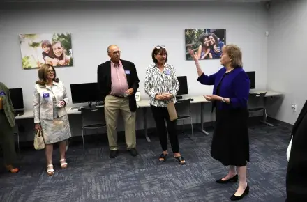 Photo from a tour, Anita Zucker and Bruce and Diane Hoffman are looking at Cathy Easley as she talks about the Center for Strong Families.