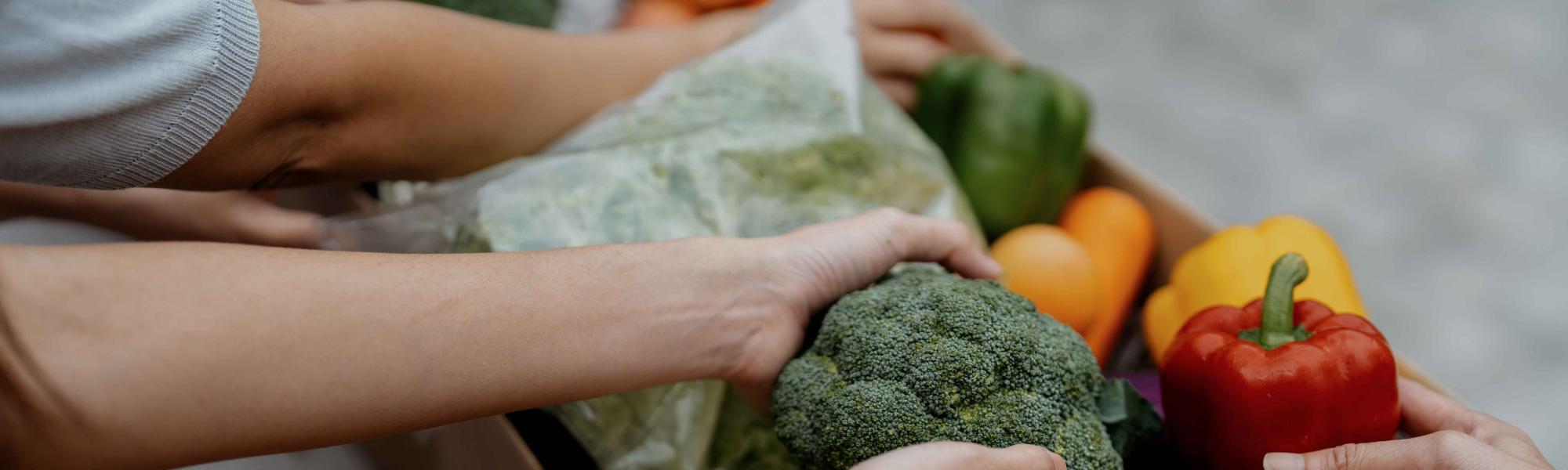 Hands taking produce out of a box