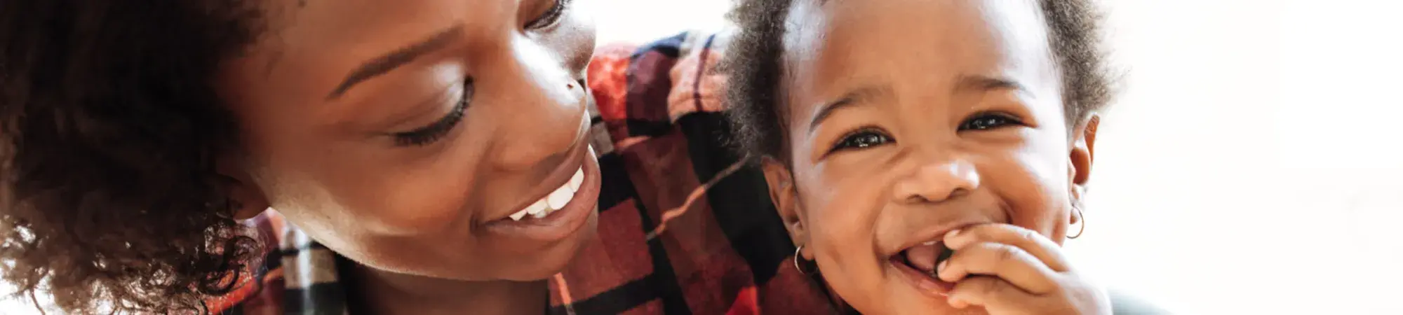A woman looks at her young child, smiling