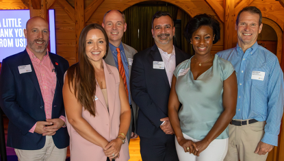 There are 6 individuals dressed in business casual, they are TUW's new board members and they are smiling at the camera. 