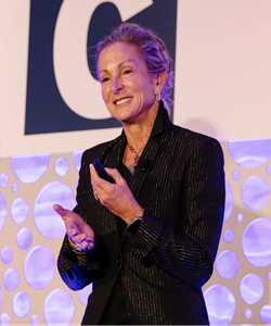 Barbara Melving standing on stage in action shot looking at audience