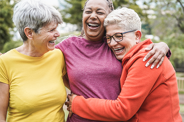 Three women smiling and laughing with each other