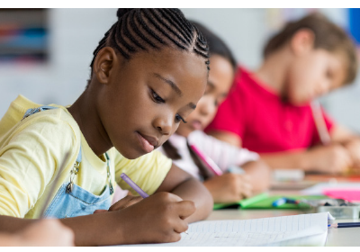 young student writing in notebook