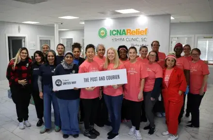Photo of volunteers from The Post and Courier and staff at the Shifa Clinic standing together in a group and smiling at the camera.