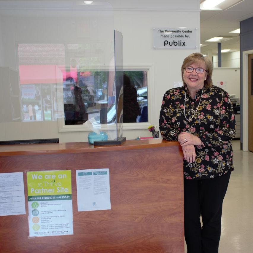 Photo of Cathy Easley standing next to the reception desk at Berkeley Resource Connection Center